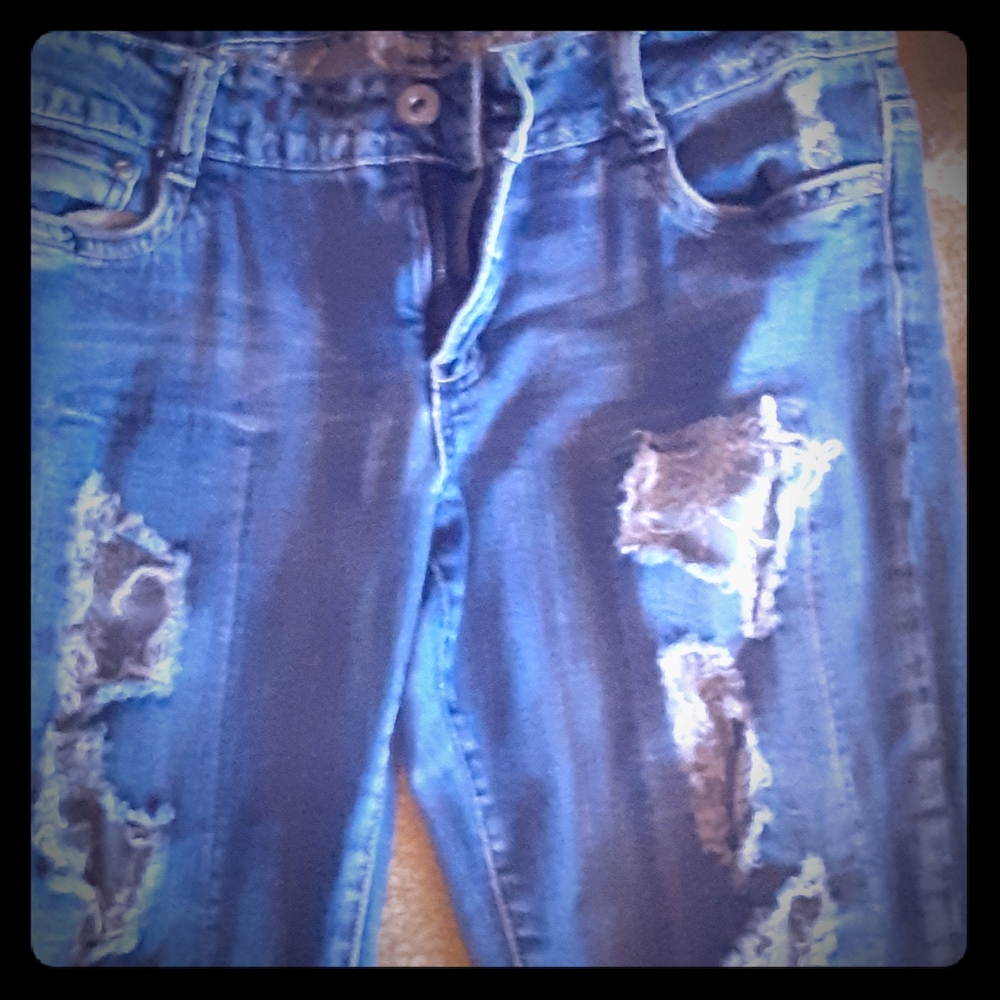 Ripped jeans with gray fabric behind rips